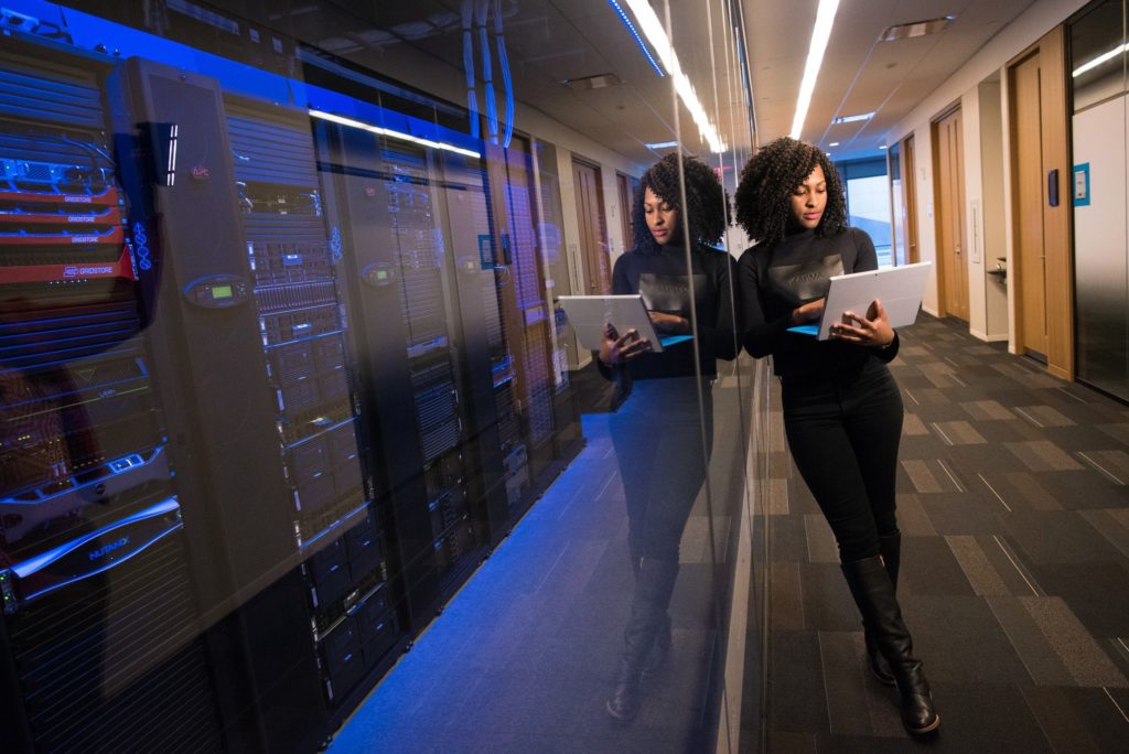 girl standing near server room holding laptop - WayPath Consulting - Microsoft Dynamics 365