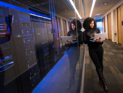 girl standing near server room holding laptop - WayPath Consulting - Microsoft Dynamics 365