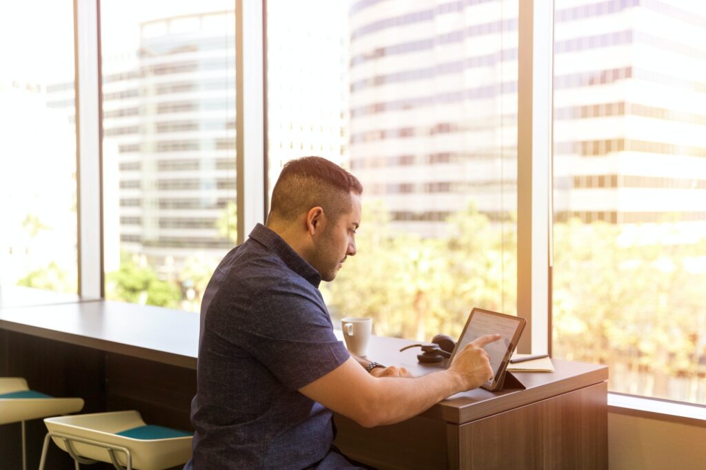 man sitting at desk using tablet | WayPath